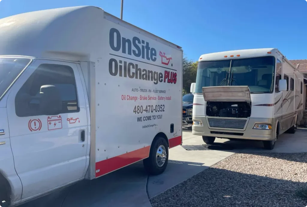 A service van labeled OnSite Oil Change Plus is parked beside a large white RV with its hood open, showing mobile auto repair and maintenance work being performed in a residential driveway on a sunny day.